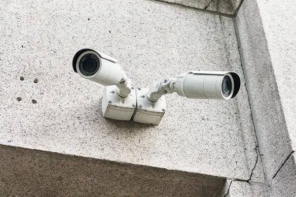 Två Vita Övervakningskameror Monterade Ett Grått Betonghörn För Säkerhetsövervakning — Stockfoto