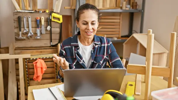 Smiling Woman Using Laptop Woodworking Workshop Surrounded Tools Wooden Furniture — Stock Photo, Image