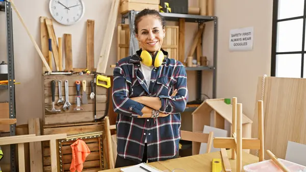 Confident Mature Woman Protective Earmuffs Stands Arms Crossed Bright Carpentry — Stock Photo, Image