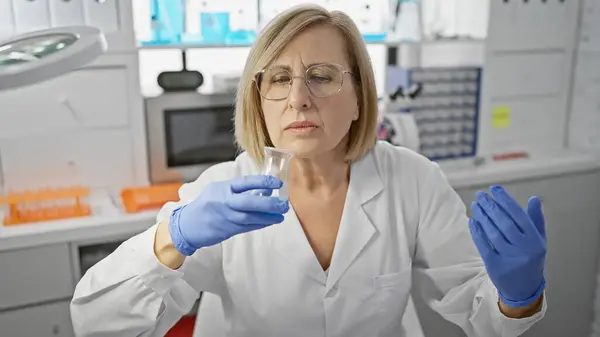 Uma Mulher Madura Cientista Examina Produto Químico Copo Com Preocupação — Fotografia de Stock