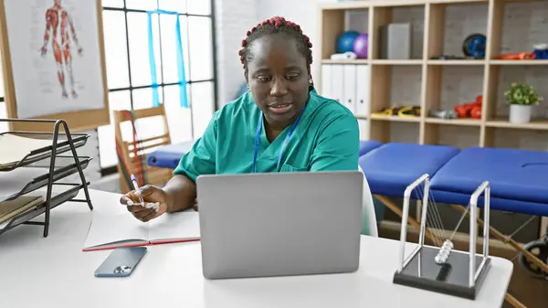 Afroamerikanerin Mit Zöpfen Macht Sich Notizen Auf Einem Laptop Innenraum — Stockfoto