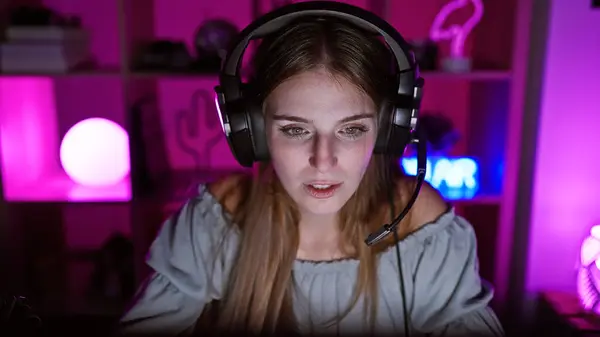 Young Caucasian Woman Headphones Neon Lit Gaming Room Looks Focused — Stock Photo, Image