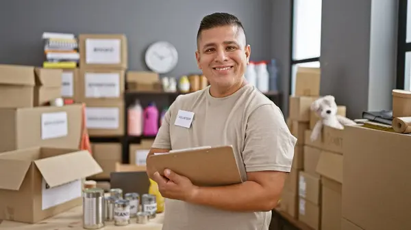 Joven Latino Confiado Sonriendo Como Voluntario Disfrutando Trabajo Escribiendo Lista — Foto de Stock