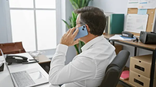 在现代办公环境中 穿着白衬衫的成熟商人在智能手机上交谈 — 图库照片