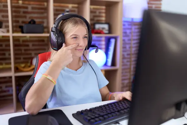 Молодая Белая Женщина Играющая Видеоигры Наушниках Указывая Пальцем Лицо Нос — стоковое фото