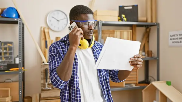 African Man Workshop Talking Phone While Examining Document Wearing Safety — Stock Photo, Image