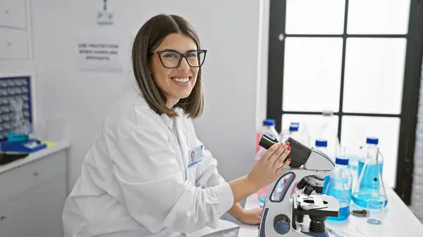 Jovem Cientista Hispânica Sorrindo Usando Microscópio Ambiente Interno Laboratorial — Fotografia de Stock