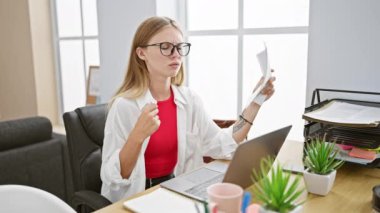 Modern ofis ortamında belgeleri analiz eden, profesyonelliği ve konsantrasyonu somutlaştıran odaklanmış genç bir kadın..