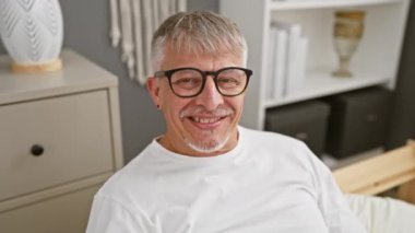 Neşeli orta yaşlı, kır saçlı, pijama giymiş eğlenceli kulakları olan, evde seçmelerde sorun yaşayan bir adam. Komik yatak odası maskaralıkları!