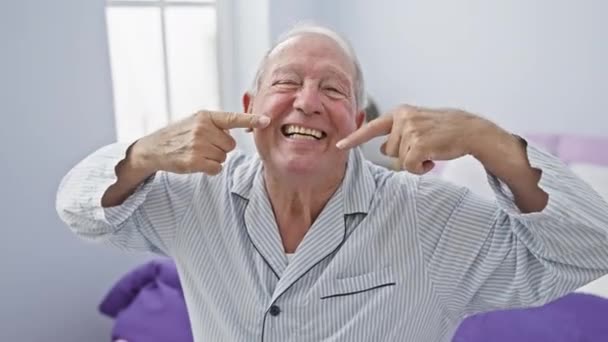 Веселый Пожилой Человек Пижаме Подчеркивает Стоматологическое Здоровье Сидя Кровати Указывая — стоковое видео