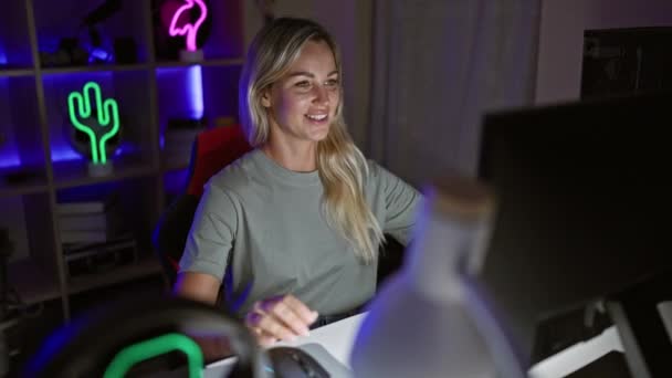 一位快乐的年轻女子在夜晚的霓虹灯下 在电脑前庆祝胜利 — 图库视频影像