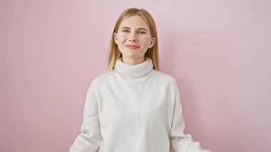 Güzel sarışın kız mutlulukla işaret ediyor, parmaklarıyla sekiz numarayı gösteriyor, pembe soyutlanmış arka planda duruyor, neşeyle gülümsüyor.