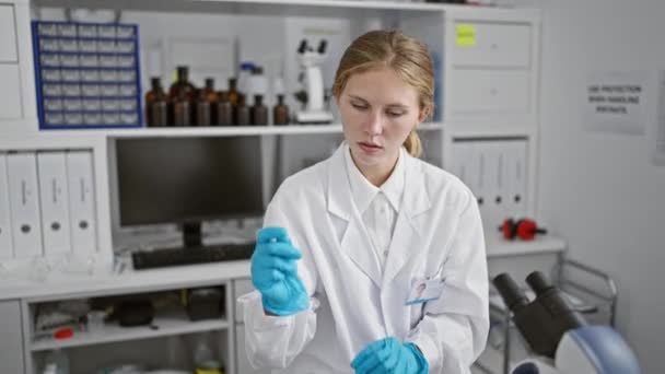 Focused Woman Scientist Examines Test Tube Laboratory Setting Surrounded Equipment — Stock Video