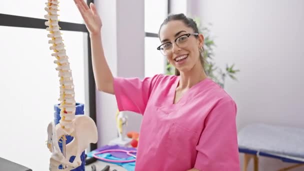 Glödande Ung Latinamerikansk Kvinna Sjukgymnast Förklarar Ryggraden Hälsa Med Anatomisk — Stockvideo