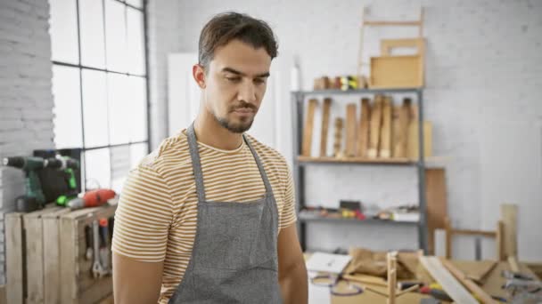 Confident Hispanic Man Workshop Wearing Apron Striped Shirt Poses Woodworking — Stock Video
