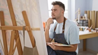 Bir sanat stüdyosundaki tuvale resim yapan, yaratıcılığı ve zanaatkarlığı somutlaştıran İspanyol bir adam..