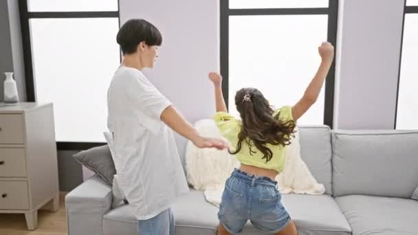 快乐的母亲和女儿自信地共舞 在他们家的客厅里欢快地舞动着 一边听着欢快的歌声 — 图库视频影像