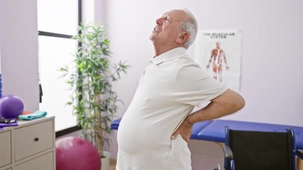 Älterer Mann Mit Quälenden Rückenschmerzen Unterzieht Sich Reha Klinik Physiotherapie — Stockvideo