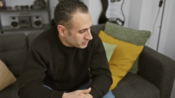 Seorang Pria Hispanik Kontemplatif Duduk Nyaman Ruang Tamu Modern Memancarkan — Stok Video