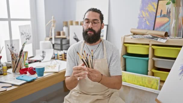 Hombre Barbudo Estudio Sostiene Pinceles Rodeado Materiales Arte Exudando Creatividad — Vídeo de stock