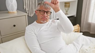 Alay eden, aşağılayan, gri saçlı, orta yaşlı, pijama giyen, alnında ezik sembolü olan, yatak odasındaki konfordan insanlarla alay eden biri.