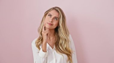 Heyecanlı genç sarışın kadın, pembe bir arka plan üzerinde gömlek içinde, parmağını mutlu bir ifadeyle gösteriyor, bir numaralı başarı fikrini kutluyor.!