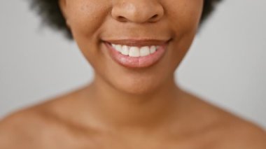 Beyaz yalıtılmış arka planda gülümseyen Afrikalı Amerikalı kadın mutluluk ve güven gösteriyor.
