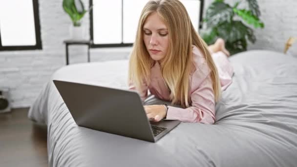 Mulher Loira Deitada Cama Usando Laptop Quarto Moderno Com Luz — Vídeo de Stock