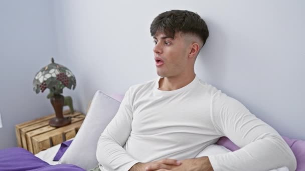 Surpreso Jovem Hispânico Pijama Deitado Seu Quarto Expressão Assustada Boca — Vídeo de Stock