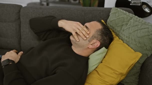 Hombre Hispano Estresado Descansando Sofá Interior Con Una Mano Frente — Vídeo de stock