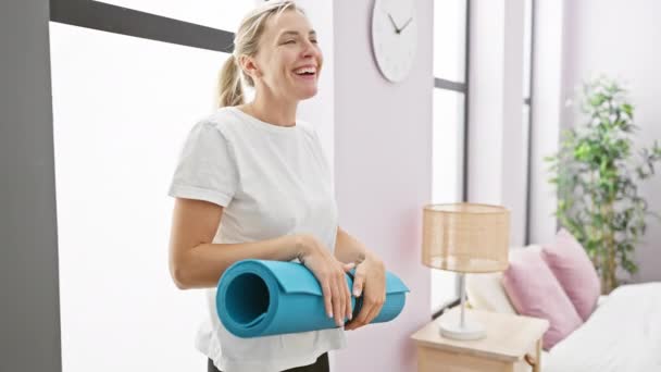 Joyful Blonde Woman Holds Yoga Mat Bright Bedroom Portraying Active — Stock Video