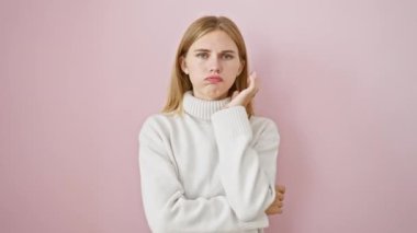 Güzel sarışın kız, sıkılmış ve yorgun, kollarını kavuşturmuş, depresyon sorunlarını düşünüyor, pembe arka planda soyutlanmış.