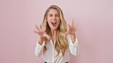 Komik sarışın kadın pembe arka planda tek başına duruyor, gülümsüyor seksi ama agresif, gömlek giyiyor ve vahşi pençe hareketi yapıyor.