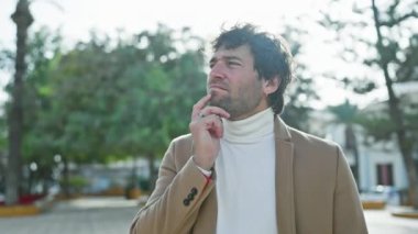 Parktaki neşeli İspanyol genç adam, parlak bir fikirle parlayan işaret parmağı, parlak bir palto içinde dimdik duran, kendine güveni ve merakı ile ışıldayan yüz..