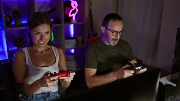 两个快乐的游戏玩家 一个是父亲 一个是女儿 一边庆祝他们的胜利 一边在家里一个舒适的游戏室里玩一个带操纵杆的数字游戏 直到深夜 — 图库视频影像