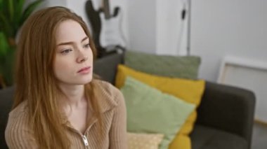 Öfkeli öfke! Süveter giyen genç sarışın kadın içeride öfkesini belli ediyor. Kızgın, sinirli, bağıran ve evde bağıran.