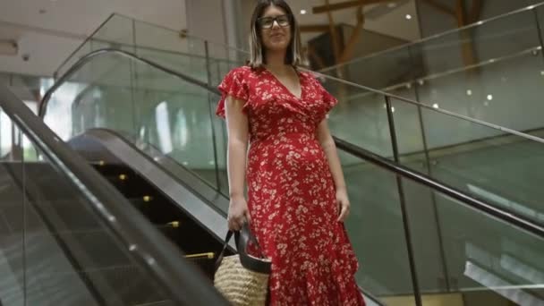 在商场自动扶梯上摆出一副眼镜的快乐而美丽的惊慌失措的女人 在市中心购物时散发出一种积极的氛围 — 图库视频影像