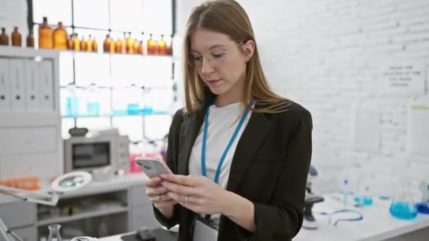 Een Jonge Blanke Vrouw Een Lab Controleert Haar Smartphone Omringd — Stockvideo