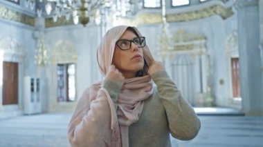 Türbanlı düşünceli bir kadın bir İstanbul camisinin iç dekorasyonuna hayran..
