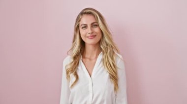 Neşeli sarışın kadın, pembe karantinada duruyor, kendine güvenen işaret ediyor, başarıyı mutlu bakışlarla onaylıyor.!