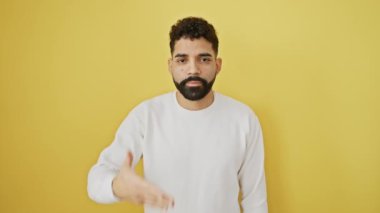 Neşeli genç bir adam bir kulağından diğerine sırıtıyor, gözleri oyunca beklenti içinde. Sarı arka planda tek başına dikilirken bir sürprizle karşılaştım.
