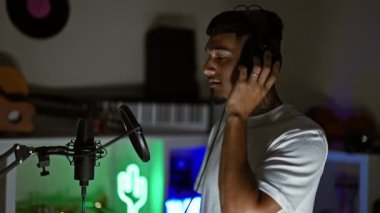 Yakışıklı genç Latin bir adam, dövmeli bir müzisyen, müzik hobisine kendini kaptırmış, loş bir müzik stüdyosunda duygusal şarkısını söylüyor, mikrofonuna ciddi bir tutku döküyor.