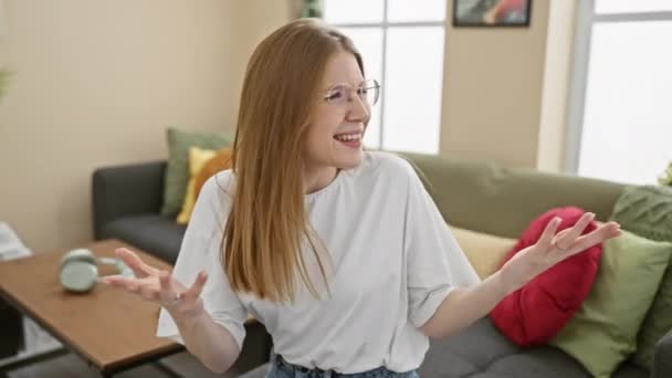 Blondynka Młoda Kobieta Okularach Gestykulująca Rozmowie Wewnątrz Jasno Oświetlonym Salonie — Wideo stockowe