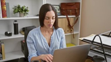 Stresli, genç, güzel, İspanyol bir ofis çalışanı. Masasında dizüstü bilgisayarla çalışırken aşırı çalışmış ve rahim ağzı ağrısı çekiyor.