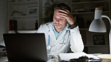 Stresli sağlık çalışanları, tıbbi ekipmanlarla çevrili çalışma yerinde geç saatlere kadar endişe ve yorgunluk göstererek klinikte çalışıyor..