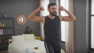 Orta yaşlı sakallı bir adam modern bir yatak odasında egzersiz yapıyor, güçlü ve sağlıklı bir yaşam tarzı sergiliyor..