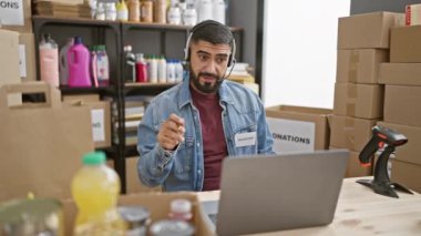 Depoda sakallı bir adam. Bağış kutuları ve ev eşyalarıyla dolu..