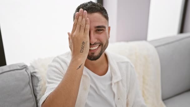 Domu Pewny Siebie Młody Arabski Mężczyzna Siedzący Kanapie Salonie Zakrywający — Wideo stockowe