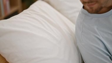 Sakallı, rahat bir genç adam evinde rahat bir şekilde uzanıyor. Huzur ve huzuru gösteriyor..