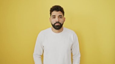 Yorgun genç bir adam, tembel gözlerinde yorgunluk, akşamdan kalma görünüyor ve uykulu görünüyor. Sabahları parlak sarı bir arka planda tek başına duruyor..